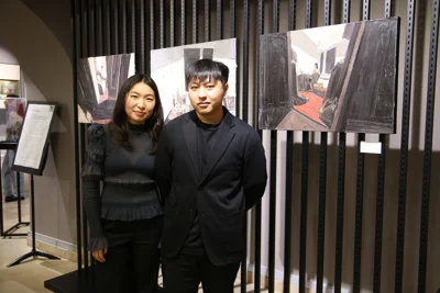 Куратор выставки, искусствовед Виктория Пан и художник Саян Байгалиев с его работами