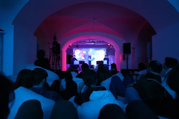 Исполнение перформанса Элвина Люсье “I Am Sitting In a Room” в пространстве выставки «Импросхема». Арт-пространство «Артемьев»